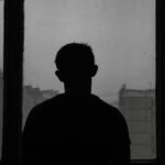 silhouette of a man standing near a window